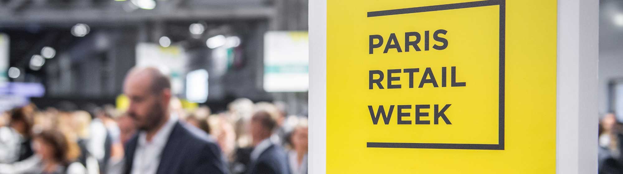 Crowd of visitors behind a sign with Paris retail Week on it