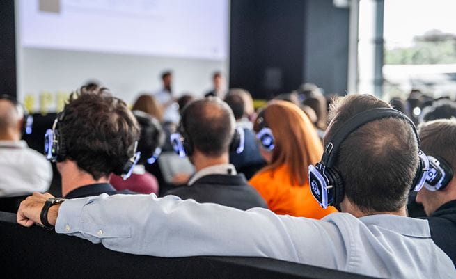 Visitors wearing headphones during a workshop