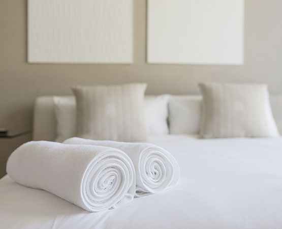 A white bed in a hotel room