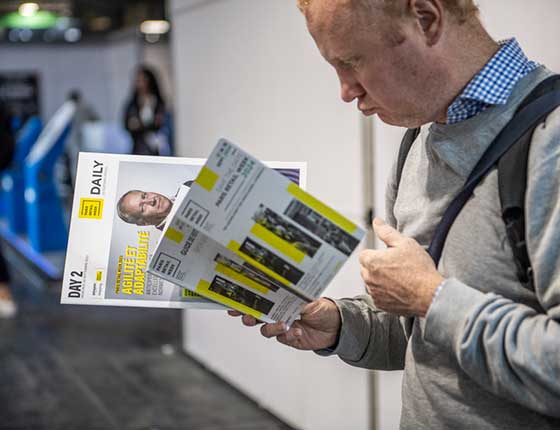 person reading a Paris retail Week magazine